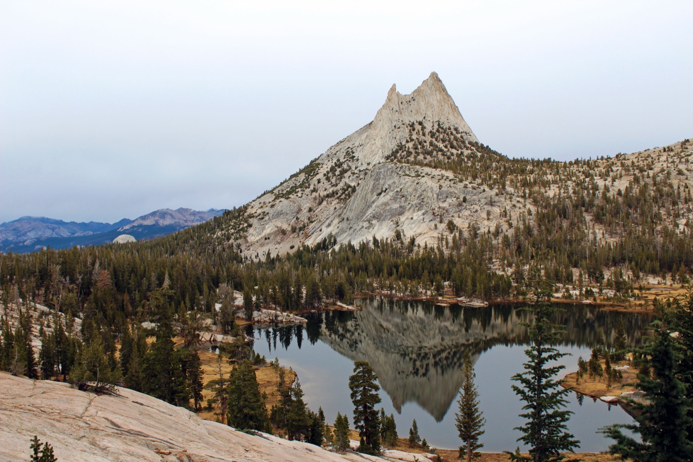 A granite peak reflecting in a still lake at Yosemite